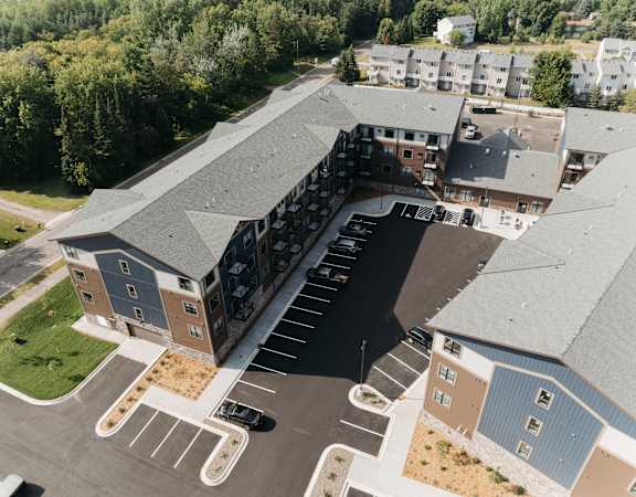 an aerial view of an apartment building with a parking lot