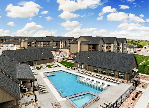 an aerial view of a swimming pool with apartments in the background
