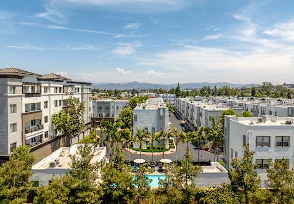 A view of apartment buildings with a pool in the foreground.