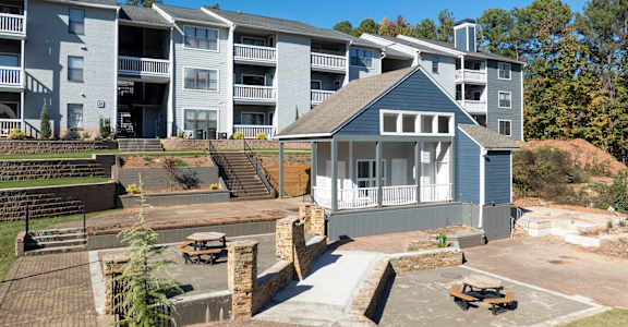 A large apartment complex with a small house in the foreground.