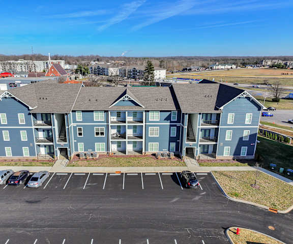 A large blue building with a parking lot in front.