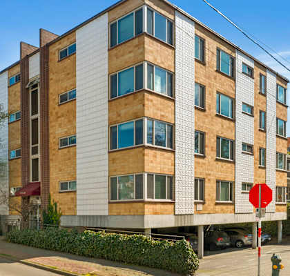 an apartment building on a street corner with a stop sign