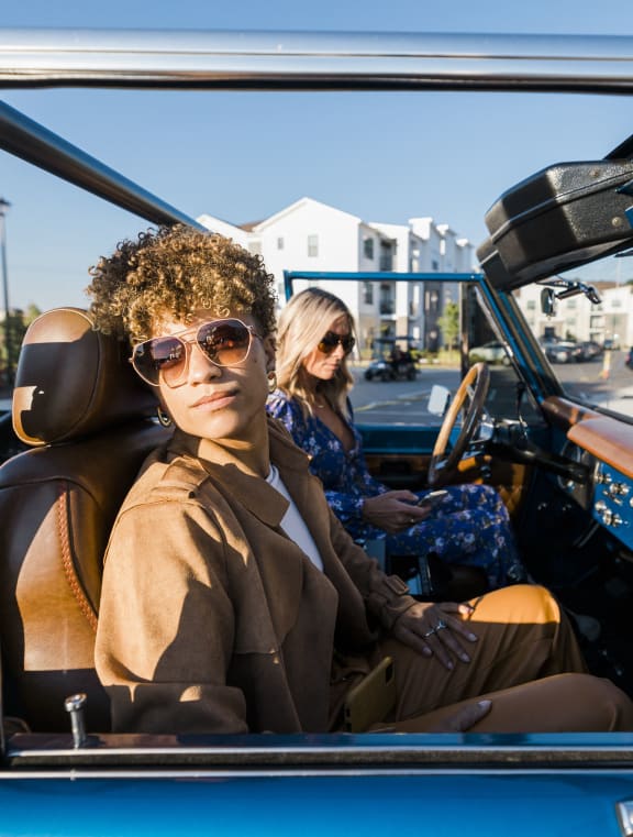 two women sitting in a convertible car