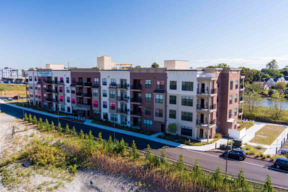A large apartment complex with multiple buildings and a parking lot in front.