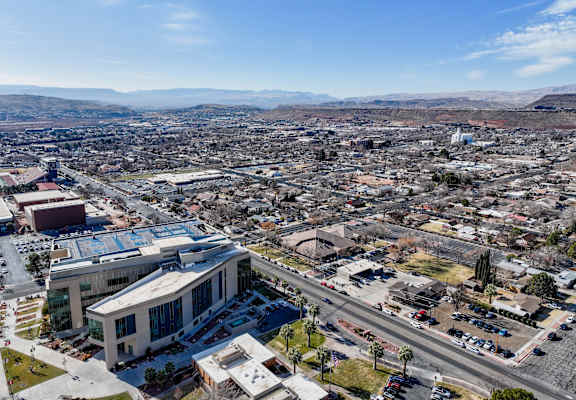 A large building with a glass facade is the focal point of a bustling cityscape.