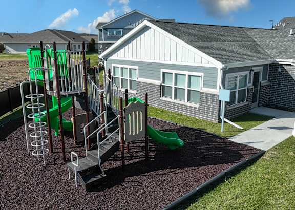 A blue and white townhouse with a front yard and a driveway.at Hawthorne Pointe, Bondurant, 50035