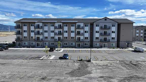 an empty parking lot in front of an apartment building