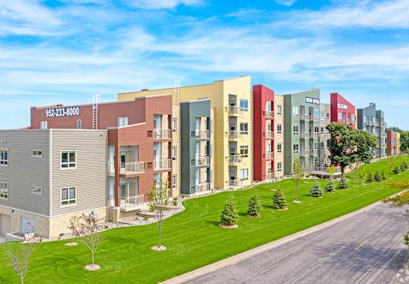 A row of colorful apartment buildings with a road in front.