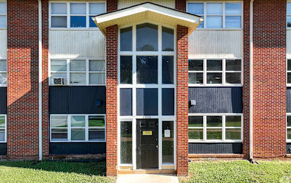 A building with a black door and windows with white frames.