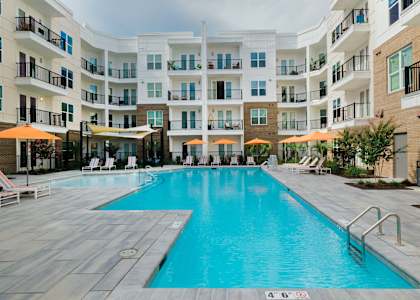 A large swimming pool in front of apartment buildings.