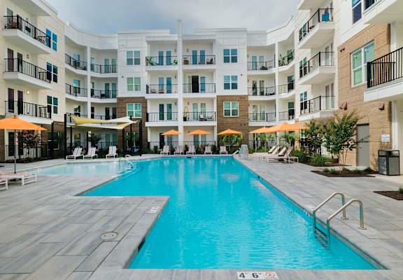 A large swimming pool in front of apartment buildings at Hudson at Renaissance Apartments, Wilmington, NC 28405