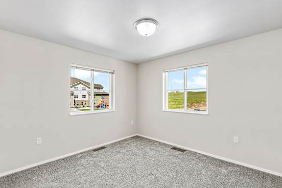 A room with two windows and a picture on the wall.