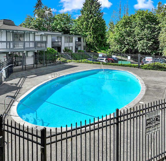 A pool surrounded by a black fence with a sign that says closed.