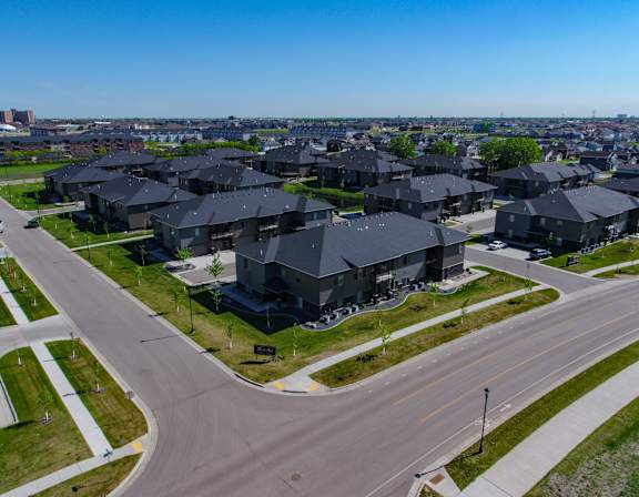 A suburban neighborhood with houses and cars parked on the street.