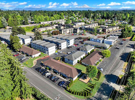 A large building complex with a parking lot in front.
