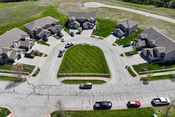 an aerial view of a suburban neighborhood with cars parked in front of houses