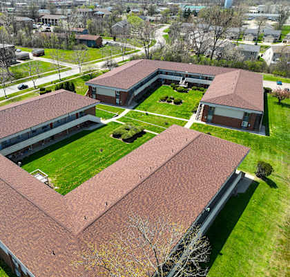 arial view of the roof of a building with a green lawn