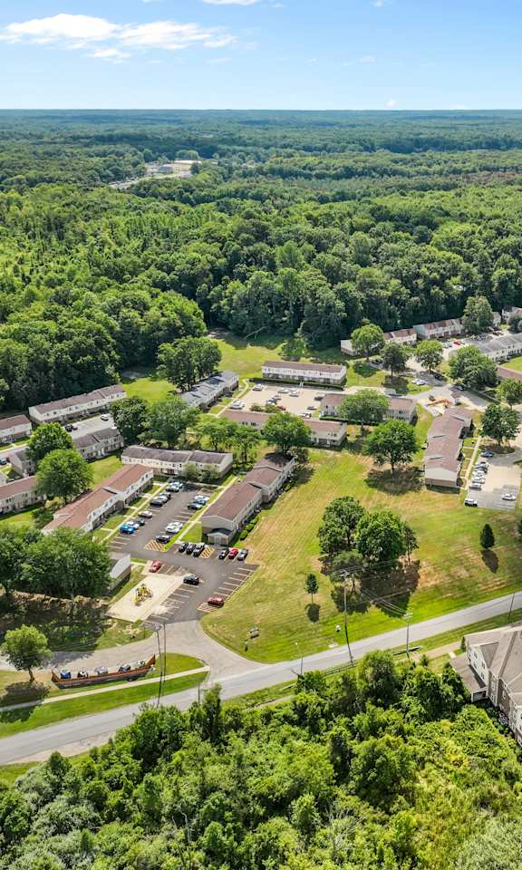 A bird's eye view of a residential area with houses and parked cars.