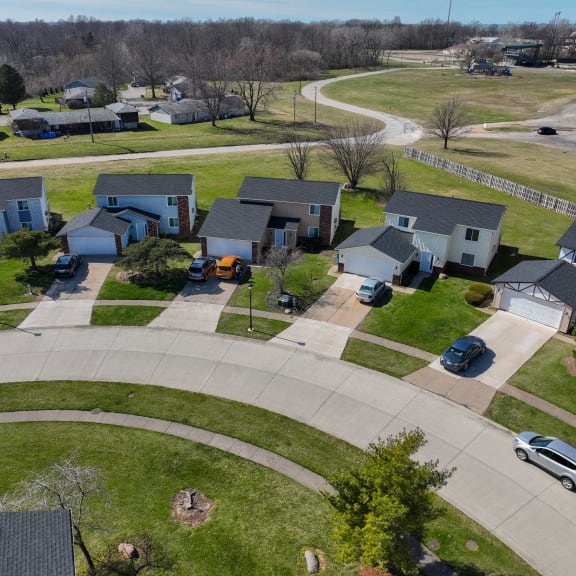 an aerial view of a neighborhood of houses with cars parked