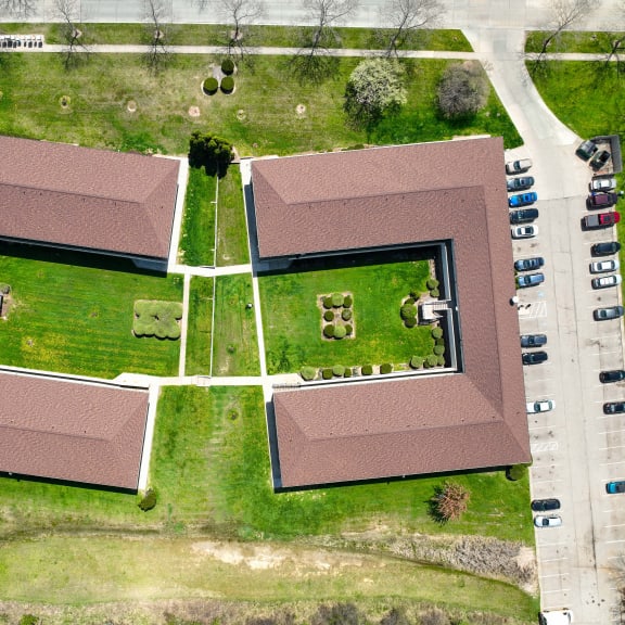 an overhead view of a building with grass and a parking lot