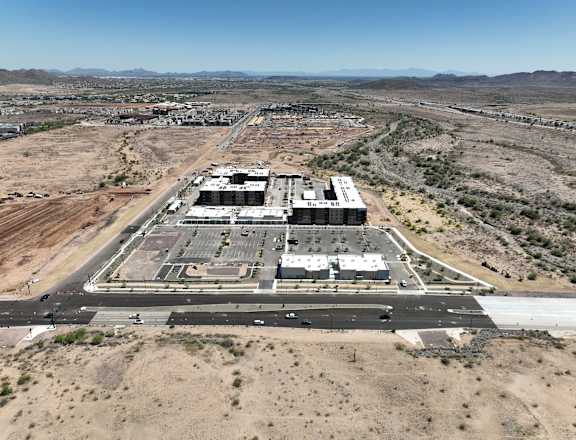 An aerial view of a large building complex surrounded by a desert landscape.
