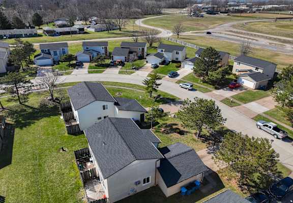 an aerial view of a neighborhood of houses with cars parked