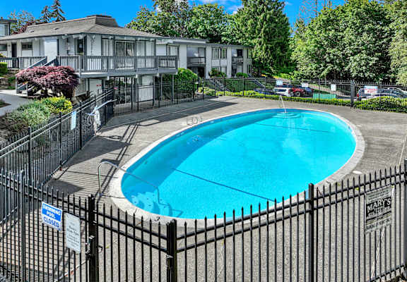 A pool surrounded by a black fence with a sign that says closed.