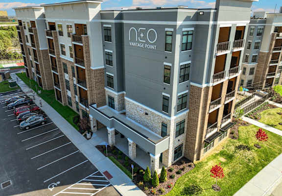 an aerial view of a large apartment building with a parking lot
