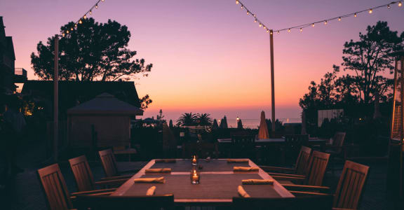 a restaurant table with chairs at sunset