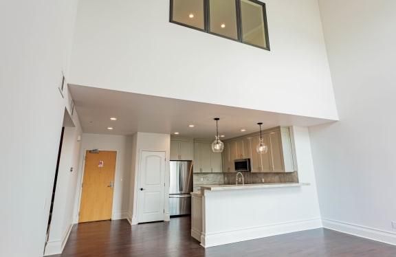 an empty living room with a kitchen and a door at Vendome Place, California