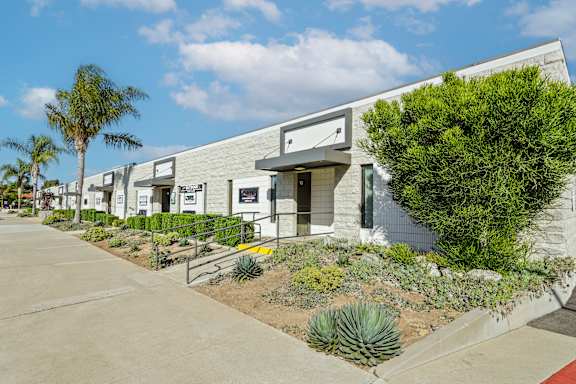 A row of modern buildings with a clear blue sky above.