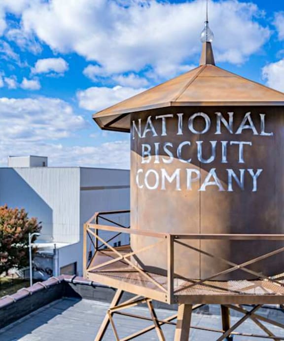 A large sign for the National Biscuit Company stands in front of a building.