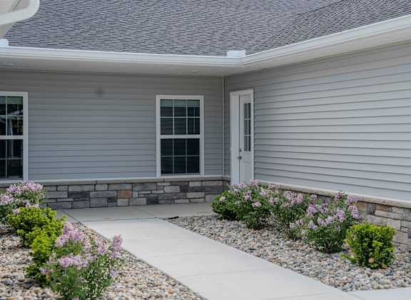 the front of a house with a sidewalk and landscaping