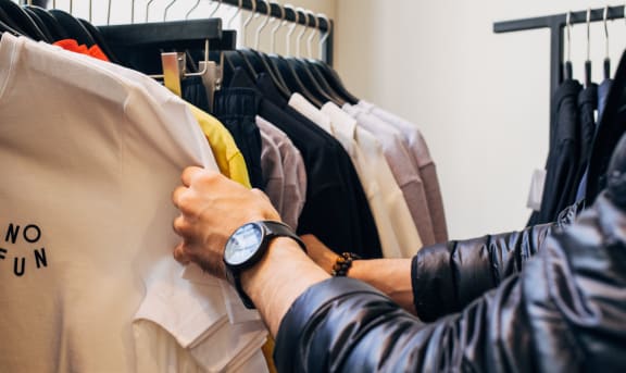 a man looking at clothes on a rack