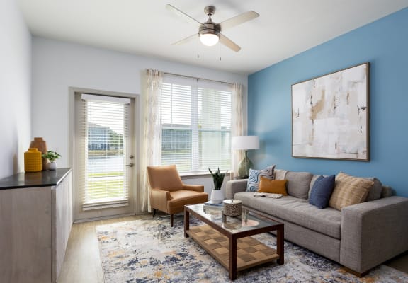 an open living room with blue walls and a ceiling fan