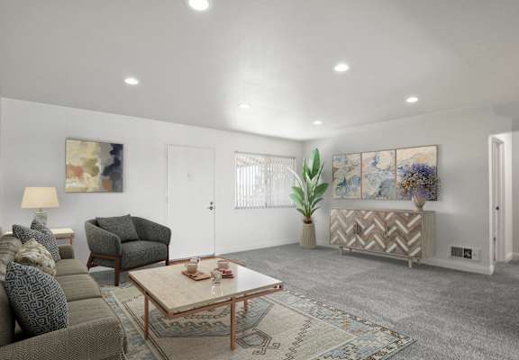 A living room with a grey couch, a brown armchair, a wooden coffee table, and a rug.