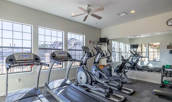 gym with cardio equipment and windows