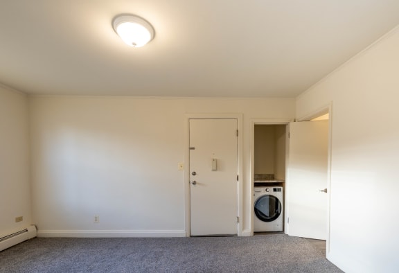 a living room with a washer and dryer and a door to a bathroom at Loch Bend Apartments, Baltimore, MD, 21234
