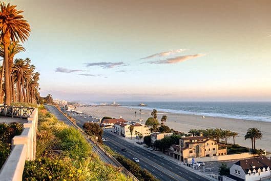 a city with a beach and a highway and palm trees