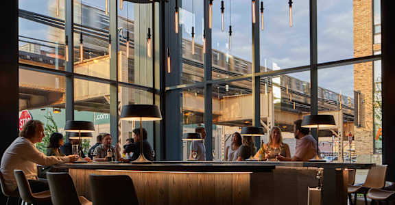 A group of people are sitting at a bar with a view of the city. at The Mason Apartments, Illinois, 60607