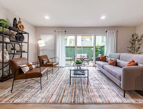 A living room with a grey couch, a brown chair, and a coffee table.