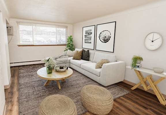 A living room with a white couch, a wooden coffee table, and a woven ottoman.
