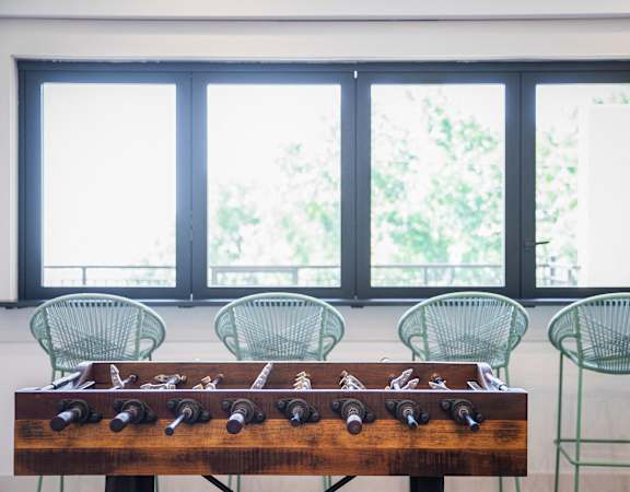 a table with a chess board and chairs in front of a window