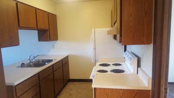 Image showing sink, cabinets refrigerator, and stove with range hood