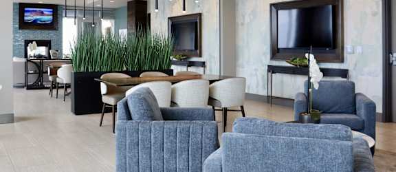 a living room with blue chairs and a table and a television