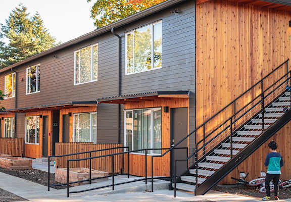 a modular home with a staircase and a porch in front of it