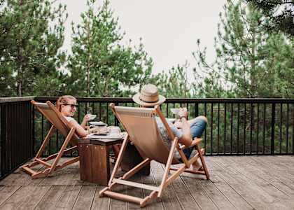 two people sitting in deck chairs on a deck