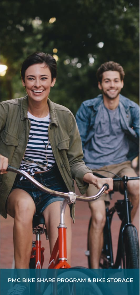 a young woman and young man on bikes underneath some trees and text that says "PMC Bike Share Program & Bike Storage"