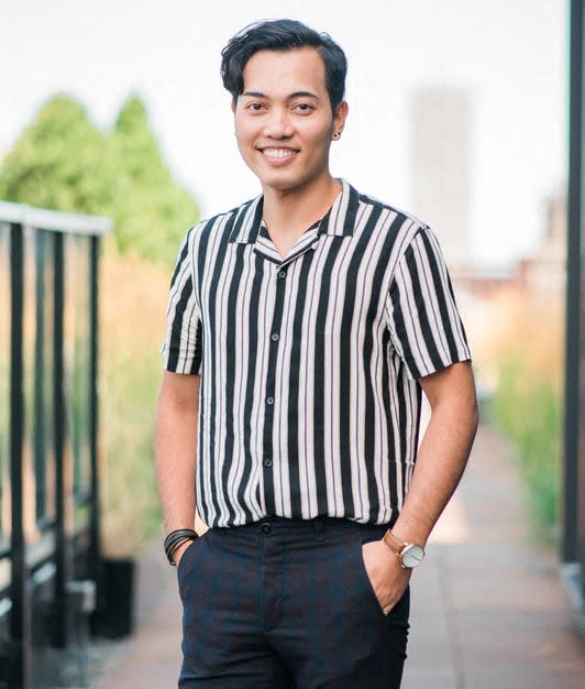 a young man wearing a striped shirt and jeans