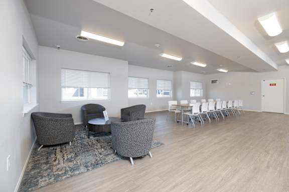 A room with grey chairs and a long table.